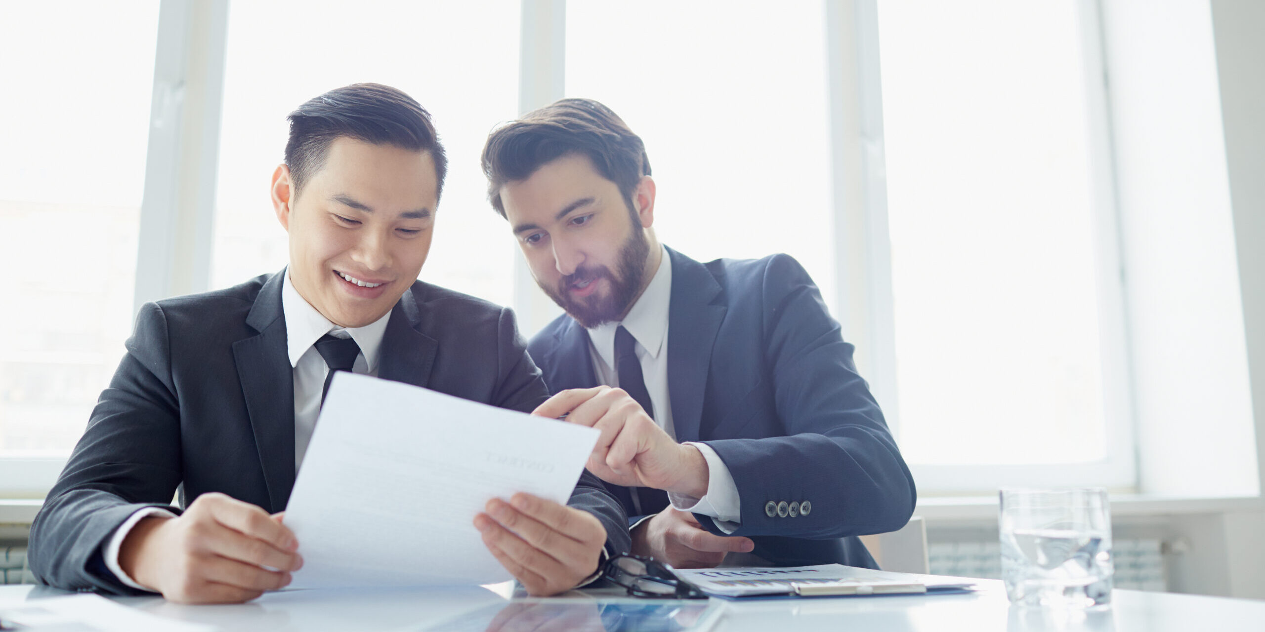 Two managers discussing contract in meeting room